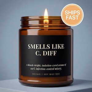 May include: A lit brown glass jar candle with a black label that reads "SMELLS LIKE C. DIFF". The candle has a "SHIPS FAST" sticker. The text below the title reads "A bleach-bright, isolation-ward aroma of 100% infection-control misery."