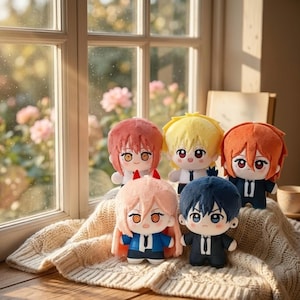 May include: A collection of five plush dolls featuring stylized anime-inspired characters with large eyes and distinct hair colors including pink, yellow, orange, and dark blue, all wearing dark suits with white shirts and ties.