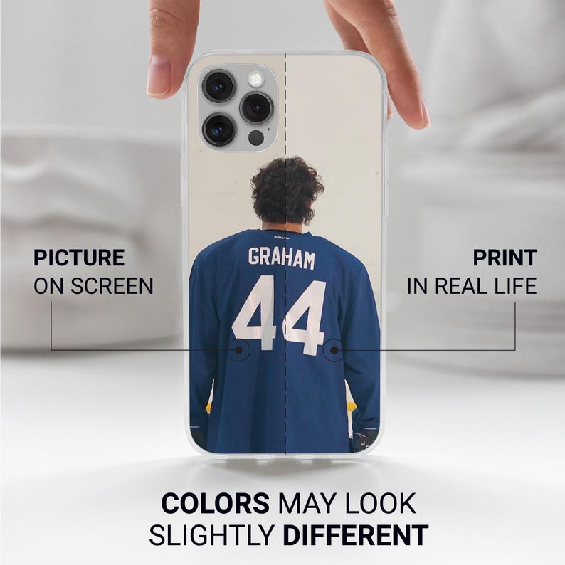 May include: Clear phone case featuring a blue jersey with the name "GRAHAM" and the number "44" in white. The text "PICTURE ON SCREEN" and "PRINT IN REAL LIFE" are also visible. The bottom of the case has the text "COLORS MAY LOOK SLIGHTLY DIFFERENT".