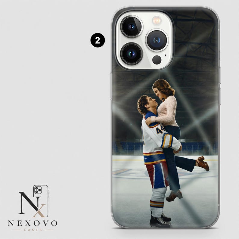 May include: Clear phone case featuring a romantic image of a couple on an ice rink. The man is wearing a hockey uniform and holding the woman. The case has a clear border and a logo in the lower left corner.
