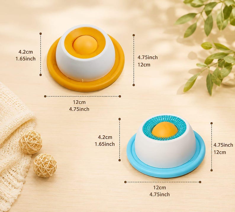 Puede incluir: Dos juguetes sensoriales en forma de c&uacute;pula con una bola amarilla central. Uno tiene base amarilla y parte superior lisa, el otro base azul y anillo azul texturizado. Ambos miden 12 cm de di&aacute;metro y 4,2 cm de altura, seg&uacute;n las etiquetas.