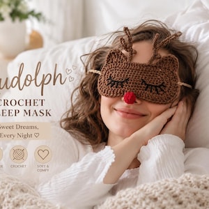 May include: A brown crochet sleep mask shaped like a reindeer with antlers and a red nose. The mask is worn by a person in bed. The image includes the text "Rudolph Crochet Sleep Mask" and "Sweet Dreams, Every Night."