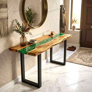 Puede incluir: Una mesa consola rectangular con una losa de madera natural de borde vivo y una incrustación de resina verde vibrante en forma de río en el centro. La mesa se apoya sobre dos patas de metal negro en forma de U y descansa sobre un suelo de mármol blanco.
