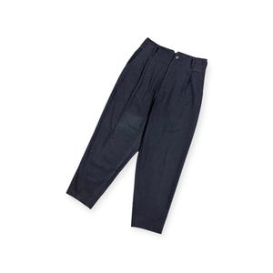Puede incluir: Un pantal&oacute;n de color gris carb&oacute;n oscuro con dise&ntilde;o de cintura alta, pliegues frontales, cierre de bot&oacute;n, cremallera y trabillas para cintur&oacute;n. La prenda presenta una silueta de pierna c&oacute;nica y un acabado de tela texturizada.
