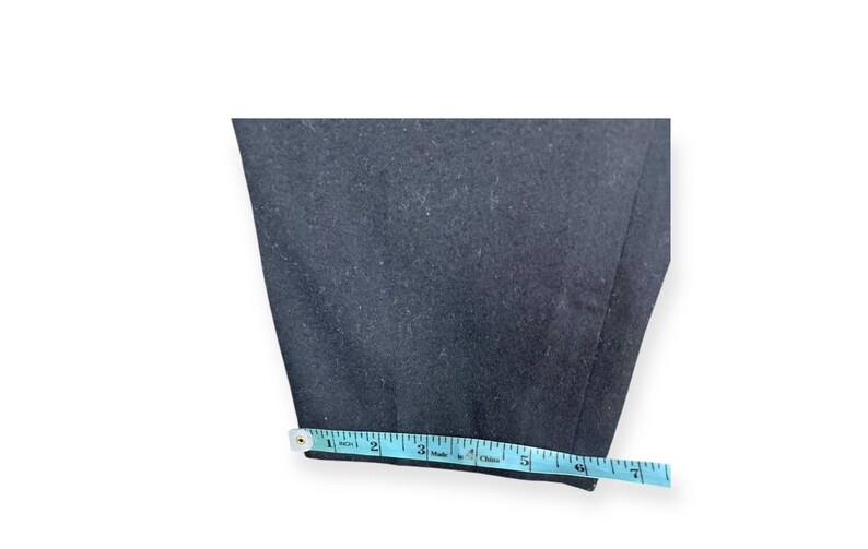 Puede incluir: Un pantal&oacute;n de color azul marino oscuro con un dobladillo recto. Una cinta m&eacute;trica de color azul claro est&aacute; colocada a lo largo del borde inferior de la tela, indicando una anchura de aproximadamente 16,5 cm en la abertura de la pierna.