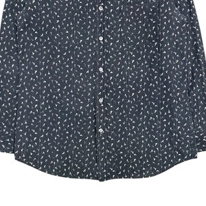 May include: A dark charcoal gray long-sleeve button-down shirt featuring a repeating white bird pattern and vertical pinstripes. The shirt includes a front chest pocket on the left side, a standard collar, and white buttons running down the center.