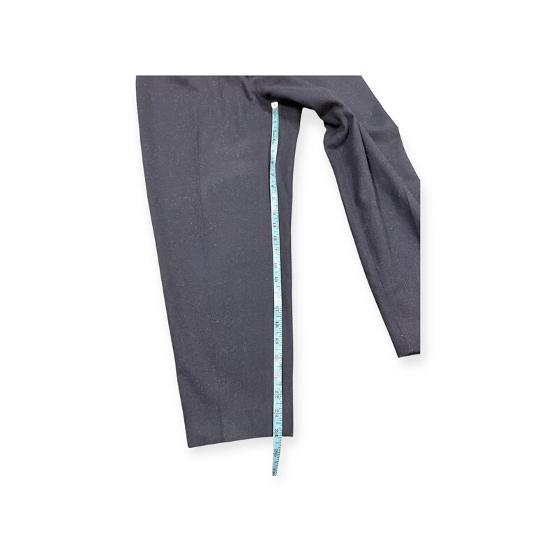 Puede incluir: Un pantal&oacute;n de color gris carb&oacute;n oscuro con corte de pierna recta. Una cinta m&eacute;trica de color azul claro est&aacute; colocada verticalmente a lo largo de la pierna, indicando una medida de longitud de aproximadamente 61 cent&iacute;metros en total.