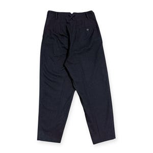 Puede incluir: Pantalones azul marino oscuro de talle alto con cintura estructurada, detalle de costura central en forma de X, trabillas para cintur&oacute;n y un bolsillo trasero ribeteado con cierre de bot&oacute;n. Corte entallado con pernera recta.