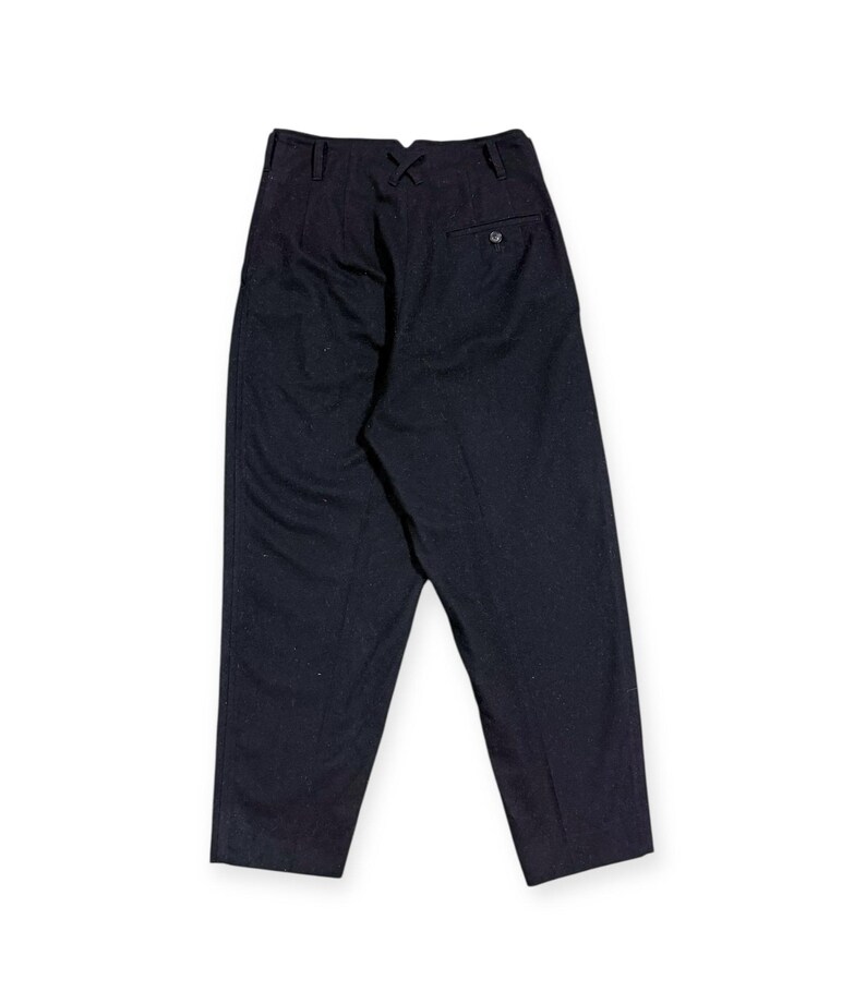 Puede incluir: Pantalones azul marino oscuro de talle alto con cintura estructurada, detalle de costura central en forma de X, trabillas para cintur&oacute;n y un bolsillo trasero ribeteado con cierre de bot&oacute;n. Corte entallado con pernera recta.