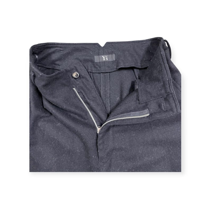 Puede incluir: Pantalones negros con cierre de cremallera frontal, un bot&oacute;n en la cintura y una etiqueta de la marca Y's cosida en el interior. Los pantalones tienen una cintura estructurada con trabillas para cintur&oacute;n y una bragueta de tela oscura.