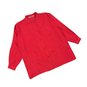 Puede incluir: Camisa roja brillante de manga larga con botones, cuello y un bolsillo en el pecho. La camisa tiene un dise&ntilde;o cl&aacute;sico y est&aacute; hecha de una tela suave. El nombre de la marca es visible en el cuello.