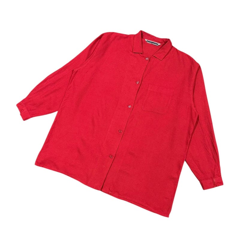Puede incluir: Una camisa roja brillante de manga larga con botones, cuello y un bolsillo en el pecho. La camisa tiene un dise&ntilde;o cl&aacute;sico y est&aacute; hecha de una tela ligera. El nombre de la marca es visible en el cuello.
