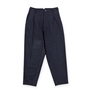 Puede incluir: Pantalones azul marino oscuro con dise&ntilde;o de cintura alta, cierre de un solo bot&oacute;n, cremallera, trabillas para cintur&oacute;n y pliegues frontales. Los pantalones tienen una silueta de pierna c&oacute;nica con una textura sutilmente moteada.