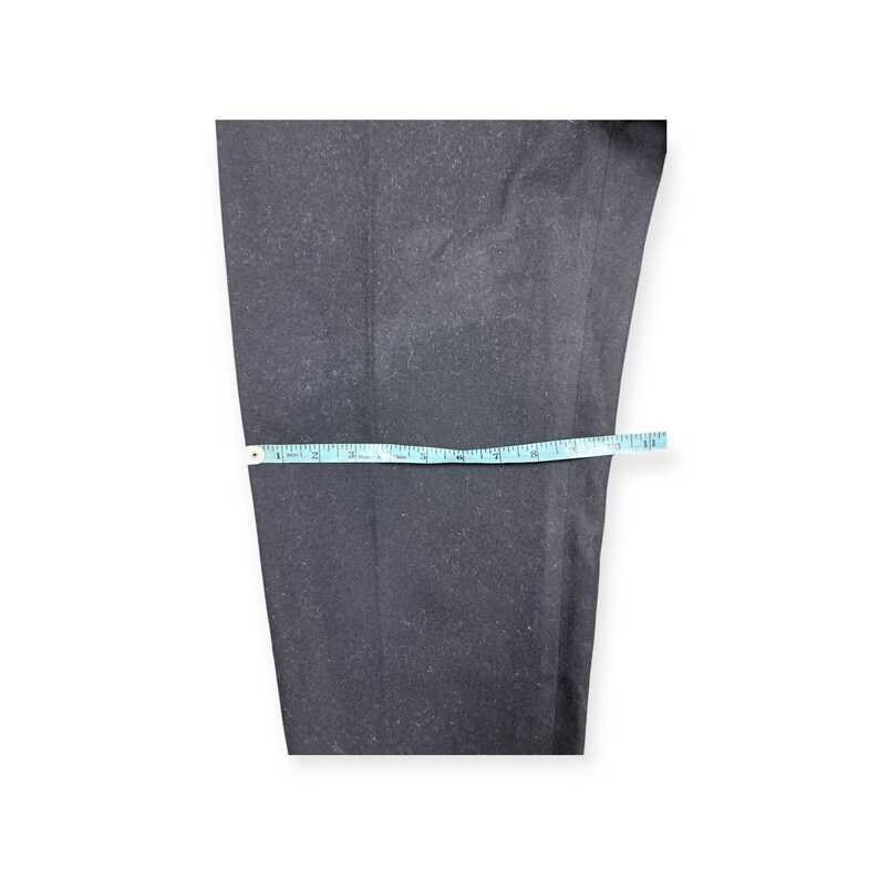 Puede incluir: Un pantal&oacute;n de color gris carb&oacute;n oscuro con corte recto. Una cinta m&eacute;trica de color azul claro est&aacute; colocada horizontalmente sobre la tela, indicando una medida de ancho de aproximadamente 28 cm en este punto espec&iacute;fico de la prenda.