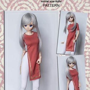 May include: A doll wearing a red jersey long tunic with gold trim and white pants. The image includes the text "JERSEY LONG TUNIC" and "PATTERN". The doll has long silver hair and blue eyes. The product is for smart dolls.