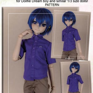 May include: A purple button-down shirt for a Dollfie Dream boy doll. The shirt has short sleeves and is paired with brown pants. The image includes the text "SHIRT" and "for Dollfie Dream boy and similar 1/3 size dolls!"