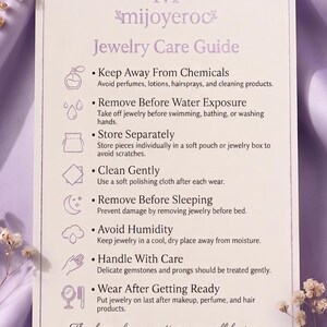 May include: A rectangular white jewellery care guide card with rounded corners featuring the text mijoyeroc and instructions to keep away from chemicals, remove before water exposure, store separately, clean gently, remove before sleeping, avoid humidity, handle with care, and wear after getting ready.