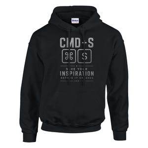 May include: Black hooded sweatshirt with a front graphic. The graphic features the text "CMD-S" above a symbol and the letter "S" inside a square. Below the text is "SAVE YOUR INSPIRATION BEFORE IT CRASHES."