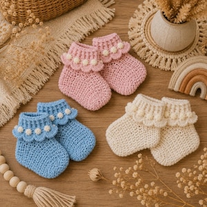 May include: Three pairs of handmade crochet baby booties in light pink, light blue, and cream. Each pair features a ribbed cuff with a scalloped edge adorned with small, white, spherical pom-poms. The booties have a textured, woven stitch pattern.