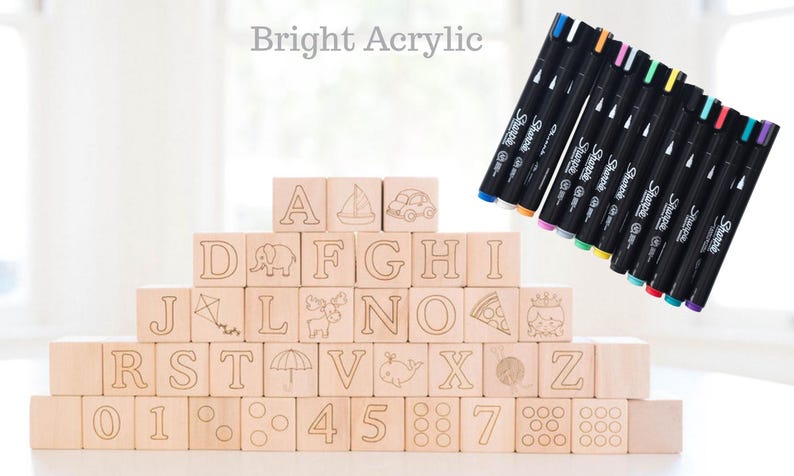 May include: Wooden alphabet blocks with engraved letters and illustrations, stacked in a pyramid. A set of Sharpie markers with various colored tips is displayed next to the blocks. The text "Bright Acrylic" is at the top.