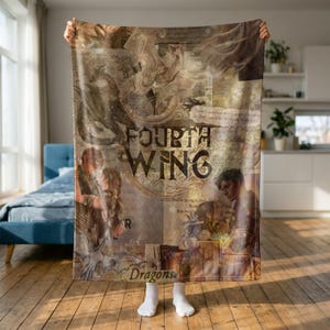 May include: A rectangular fleece blanket featuring a collage of fantasy illustrations, including dragons and two figures in an embrace. The text Fourth Wing is centred in a circular emblem, with the word Dragons printed near the bottom edge.