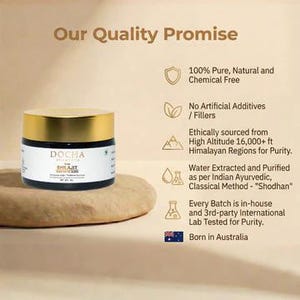 Op de afbeelding: Een pot DOCHA Shilajit met een gouden deksel en een zwart etiket, rustend op een beige, getextureerd oppervlak. De tekst op het etiket luidt "100% Puur, Natuurlijk en Chemievrij" en "Geboren in Australi&euml;."