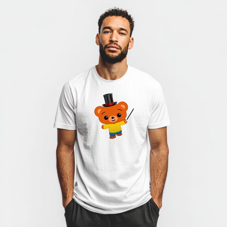May include: White t-shirt featuring a cartoon bear wearing a top hat and holding a wand. The bear is orange with a yellow shirt, blue pants, and a black top hat. The design is centered on the shirt.