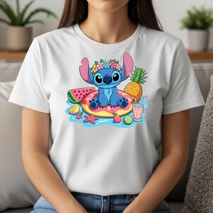 May include: White t-shirt featuring a cartoon image of Stitch, the blue alien, relaxing on a pink donut float with tropical fruits. Stitch wears a flower crown. A pineapple, watermelon, and a pink drink are also shown.