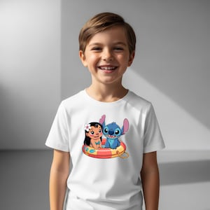 May include: White t-shirt featuring a colorful graphic of Lilo and Stitch in a life preserver. The cartoon characters are smiling. The shirt is being worn by a child.