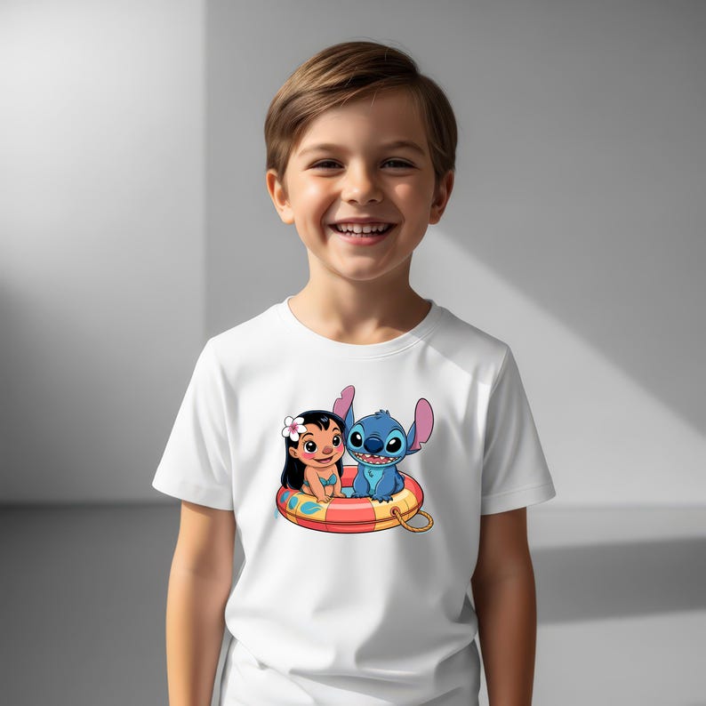 May include: White t-shirt featuring a colorful graphic of Lilo and Stitch in a life preserver. The cartoon characters are smiling. The shirt is being worn by a child.