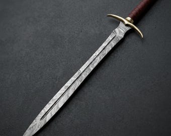 May include: A double-edged sword featuring a patterned Damascus steel blade with a central fuller. The hilt includes a curved brass crossguard, a dark brown leather-wrapped grip, and a cylindrical brass pommel at the end of the handle.