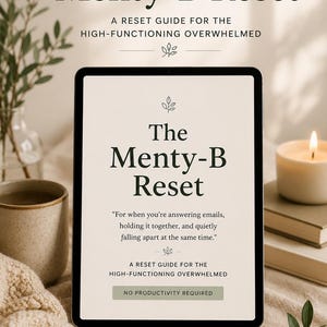 May include: A digital tablet displays the title "The Menty-B Reset" with the subtitle "A Reset Guide for the High-Functioning Overwhelmed." The image includes a candle, a mug, and a book, suggesting a theme of self-care and mindfulness.