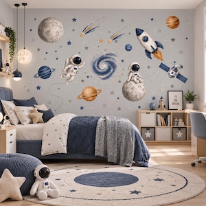 Può includere: Un set di adesivi murali con illustrazioni a tema spaziale che includono astronauti, un razzo, pianeti, stelle, una galassia e un satellite. I disegni sono disposti su una parete grigio chiaro sopra un letto, creando una scena celeste.