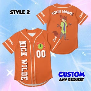 May include: An orange baseball jersey featuring the text Nick Wilde and the number 00 on the front, with a Zootopia logo on the sleeve. The back displays a graphic of a fox character, the text Your Name, and Zootopia branding on the sleeves.