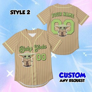 May include: Tan baseball jersey with vertical pinstripes and a Baby Yoda graphic. The front features "Baby Yoda" text and the number "00" in green. The back has "YOUR NAME" and the number "00". The jersey has the text "CUSTOM ANY REQUEST".
