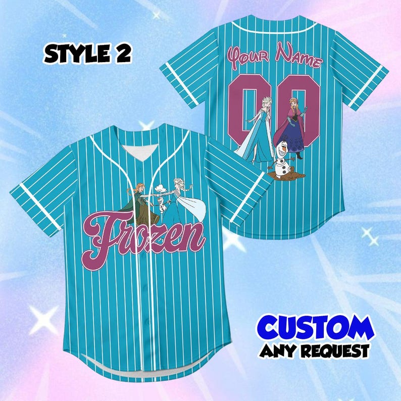 Peut inclure: Un maillot de baseball bleu sarcelle &agrave; fines rayures blanches, avec le mot Frozen en &eacute;criture violette sur le devant, ainsi qu'un nom personnalis&eacute; et le num&eacute;ro 00 au dos. Le v&ecirc;tement pr&eacute;sente des illustrations d'Elsa, Anna et Olaf.
