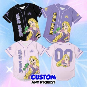 May include: Three short-sleeved button-down baseball jerseys in black, purple, and light pink, each featuring a graphic of a blonde character with a green chameleon, a castle logo, and the text YOUR NAME. A fourth light pink jersey shows the back.