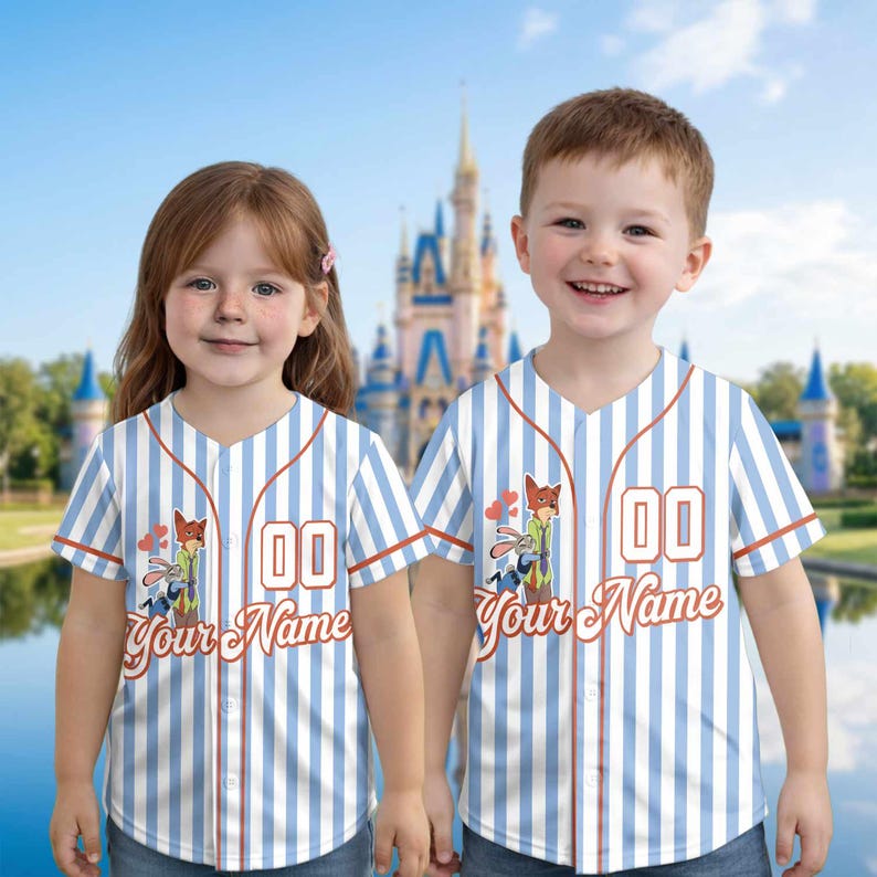 May include: Two children wearing matching baseball jerseys. The jerseys are white with blue vertical stripes and feature a cartoon fox and bunny graphic. The text "Your Name" is below the graphic, and the number "00" is on the front.