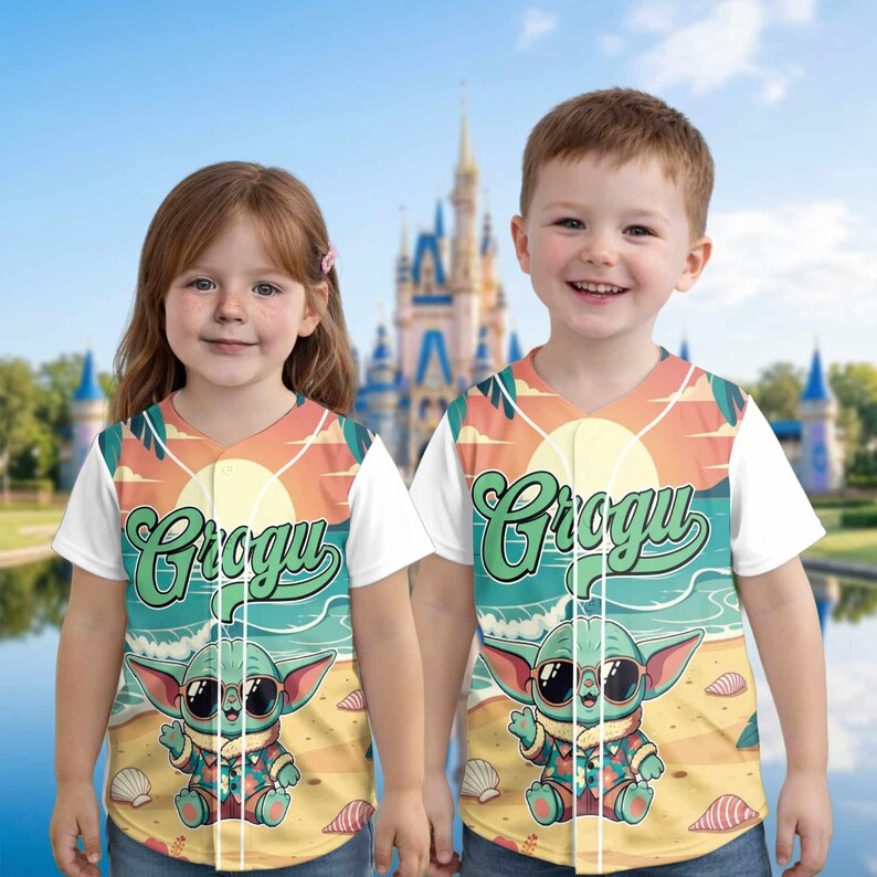 May include: Two children wearing baseball jerseys with a Grogu graphic. The jerseys feature a beach scene with Grogu wearing sunglasses. The word "Grogu" is written in a stylized font across the front. The background includes a sunset and ocean.