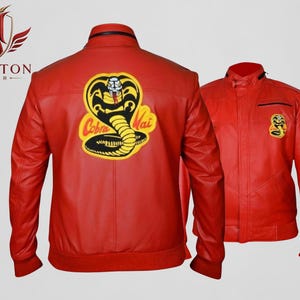 Puede incluir: Dos chaquetas de cuero rojas. Una chaqueta presenta un gran parche de Cobra Kai en la espalda y un parche más pequeño en la parte delantera. La otra chaqueta tiene un parche de Cobra Kai en la parte delantera. Las chaquetas tienen cuello alzado y dobladillo acanalado.