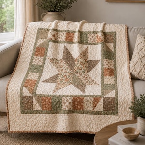 May include: A quilted throw blanket featuring a central star pattern composed of floral and solid fabric patches in shades of cream, sage green, and terracotta. The border consists of alternating square blocks with matching floral and solid prints.