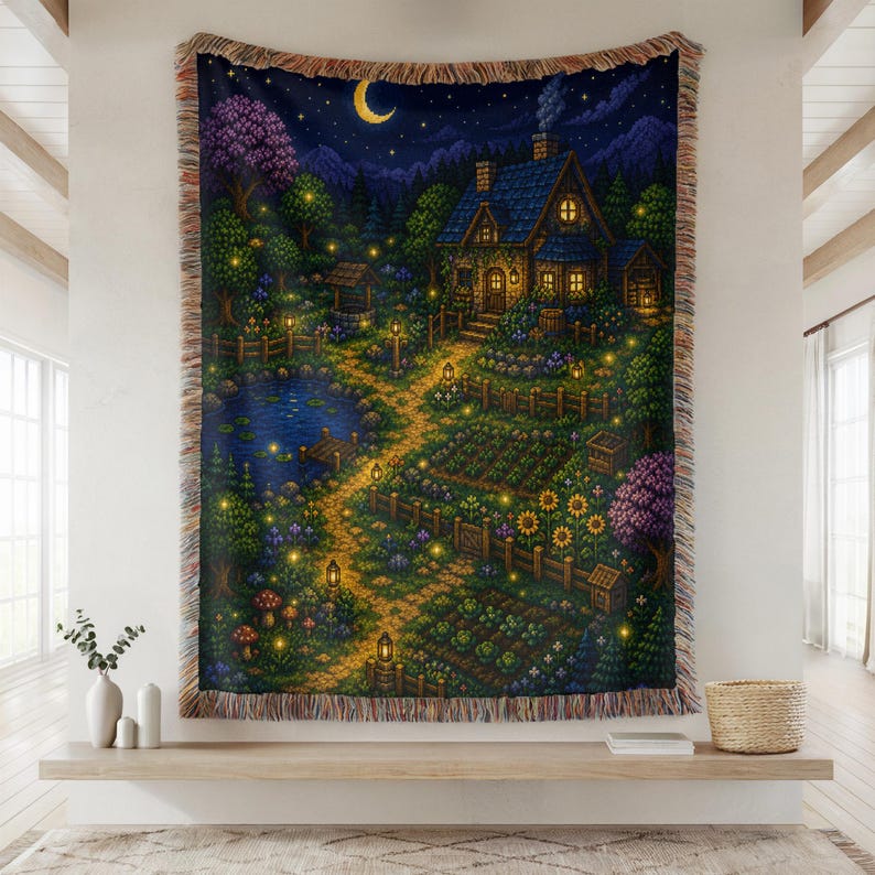 May include: Woven tapestry featuring a pixelated illustration of a cozy cottage at night. The scene includes a path, garden, pond, and a crescent moon. The color palette is dominated by blues, greens, and warm yellow lights, creating a whimsical and inviting atmosphere.