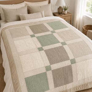 May include: A quilted bedspread featuring a geometric block pattern in shades of sage green, beige, and cream. The quilt is constructed with square panels separated by thin strips and small square accents, finished with a solid beige border.