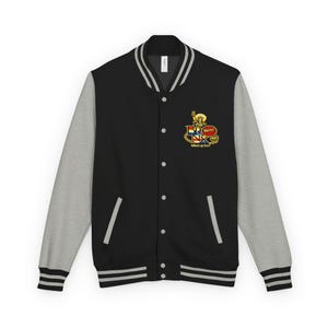 May include: Black varsity jacket with gray sleeves. The jacket features a white collar and cuffs with black stripes. A colorful emblem with the text "THE BRONX" and "Yererr!" is on the chest. The phrase "What's up bro?" is also visible.
