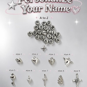 May include: A collection of silver-toned metal components for jewelry making, including round alphabet beads from A to Z, a plus sign bead, and nine distinct charm styles featuring hearts, a lock with wings, a key, a cross, and a rose cross.