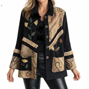 May include: A black jacket featuring tan paisley patterned panels, beige fringe trim, and embroidered floral motifs in yellow and orange. The jacket has a collared neckline, long sleeves, two front pockets, and a front button closure with five buttons.