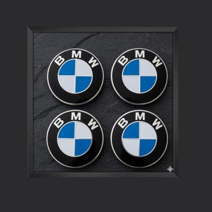 May include: A set of four circular BMW emblems featuring the iconic black outer ring with white lettering and a central quadrant design in blue and white. Each emblem has a polished finish and is arranged in a two-by-two grid pattern.
