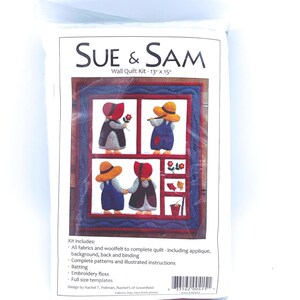 May include: A Sue & Sam wall quilt kit in a plastic package. The kit includes fabrics, woolfelt, patterns, instructions, batting, embroidery floss, and templates. The finished quilt measures 13 inches by 15 inches and features applique figures.