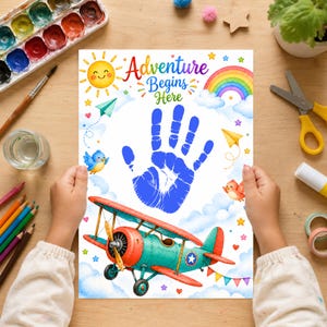 May include: A white paper print featuring the text Adventure Begins Here in colourful letters, a large blue handprint in the centre, a red and teal biplane, a yellow sun, a rainbow, clouds, small birds, paper airplanes, and colourful stars.
