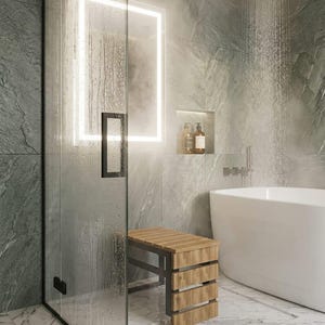 May include: A wooden shower bench with a slatted seat and side panels, featuring a dark metal frame. The bench is positioned inside a glass-enclosed shower area with grey stone-look wall tiles, a white bathtub, and a square overhead shower head.